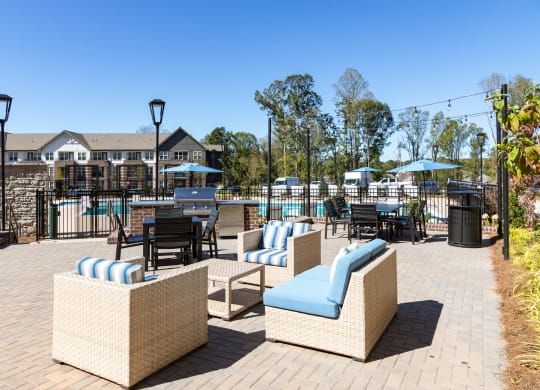 an outdoor patio with chairs and tables and a pool