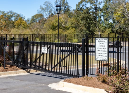 a black wrought iron gate with a sign in front of a park