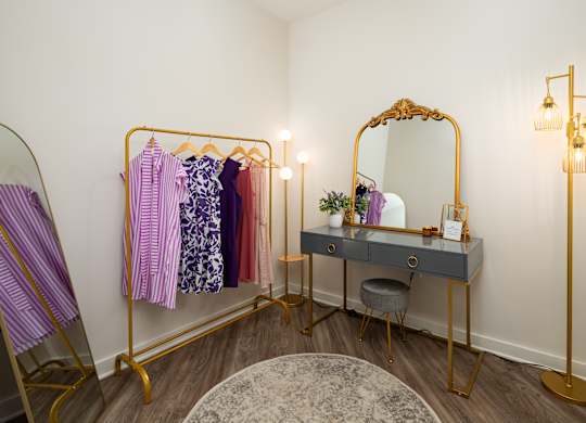 a dressing room with a black desk and a vanity with a mirror