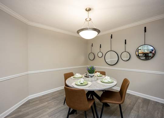 A dining room with a round table set for two.