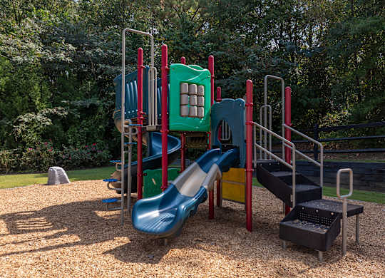 A playground with a blue slide and a green platform.