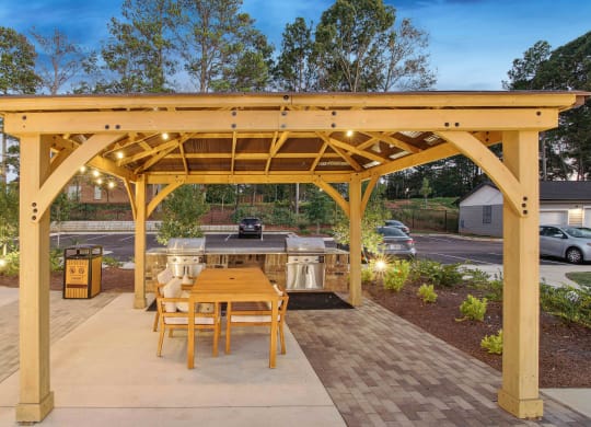 a patio with a wooden table and a wooden gazebo