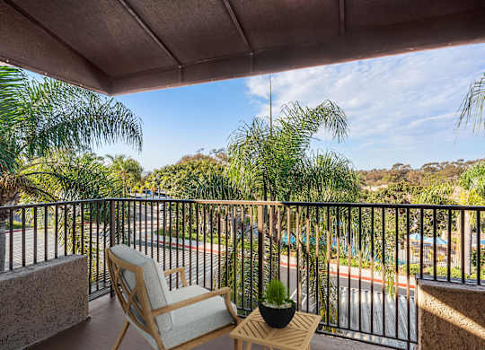 A balcony with a chair and a potted plant.