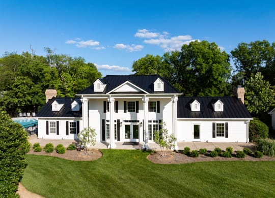 an aerial view of a white house with a black roof