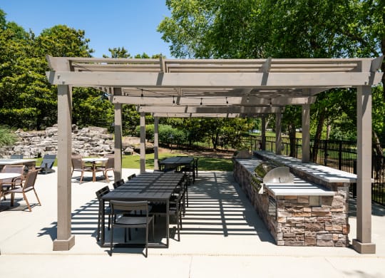 a patio with a picnic table and a barbecue grill