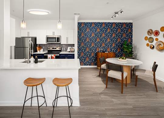 an open kitchen and dining room with a white counter top and a table and chairs