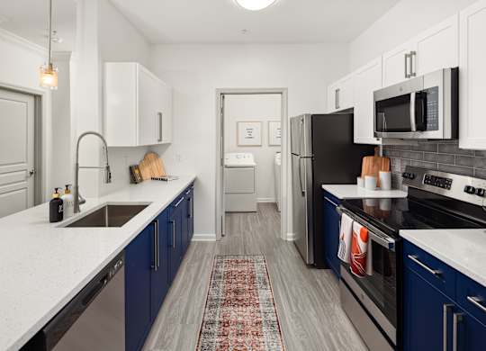 a kitchen with blue cabinets and white counter tops and a black stove and refrigerator