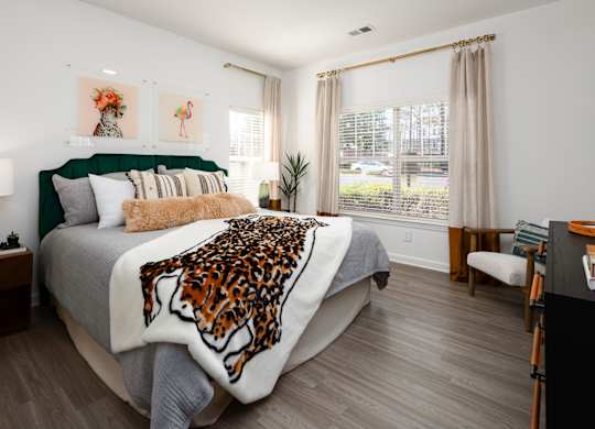 a bedroom with a bed with a leopard blanket