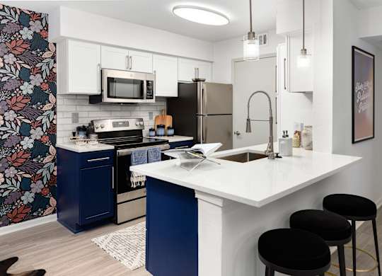 a kitchen with a white counter top and a stainless steel refrigerator