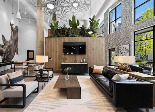 A living room with a large sofa, a coffee table, and a mounted TV.