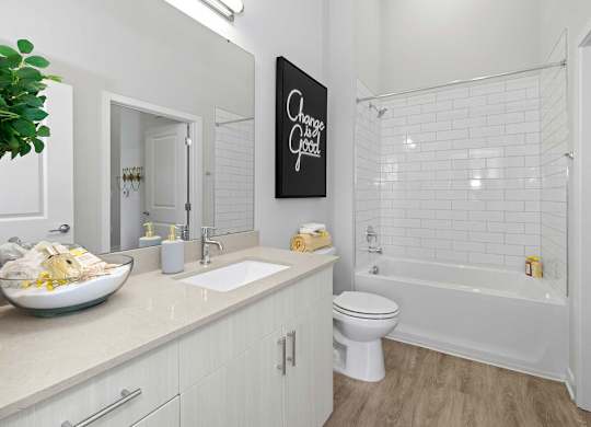 A bathroom with a white toilet and a white bathtub.