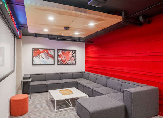 A modern room with a grey couch, a white coffee table, and two framed pictures on the wall.at Axle, Washington, 98119