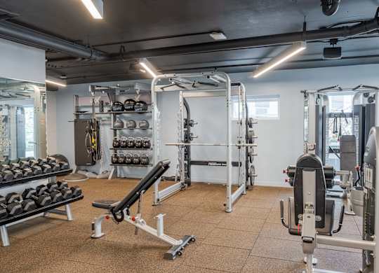 A gym with a variety of equipment including weights and weight machines.at Axle, Seattle, 98119 