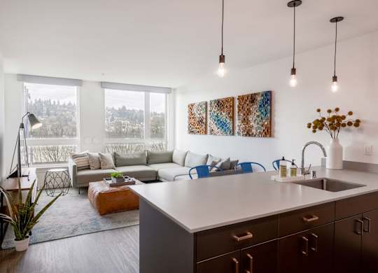 A modern kitchen with a large island and a view of trees outside the window.at Axle, Seattle Washington 