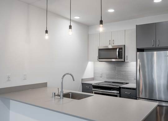 A modern kitchen with a stainless steel refrigerator and a sink with a faucet.at Axle, Washington 