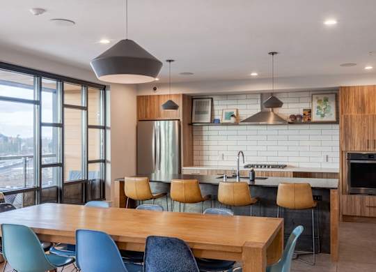 A modern kitchen with a large island and a dining table with chairs.at Axle, Seattle, WA 98119 