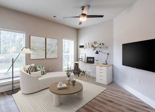 A living room with a white couch, a brown coffee table, and a flat screen TV mounted on the wall.