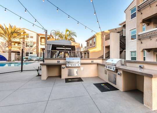 A patio with a grill and a table is set up on a rooftop.