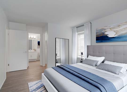 A bedroom with a large bed and a painting on the wall.