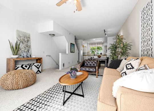 a living room with a beige couch and a black and white rug
