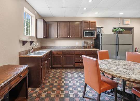 A kitchen with a table and chairs.