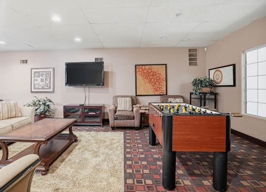 A living room with a pool table and a television.