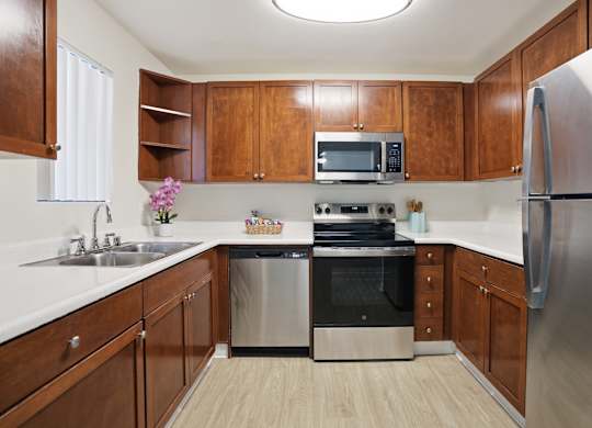A kitchen with wooden cabinets and stainless steel appliances.