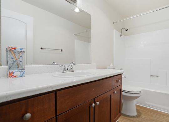 A bathroom with a white sink, toilet, and bathtub.