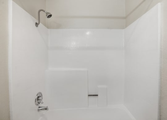 A white bathroom with a shower and a door.
