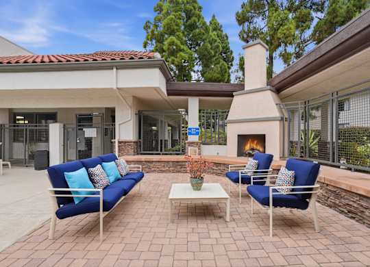 A patio with a fireplace and blue couches.