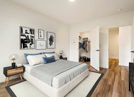 A bedroom with a large bed and a wooden floor.