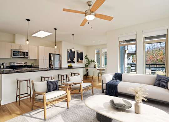 A modern kitchen with a bar area and a living room with a couch.