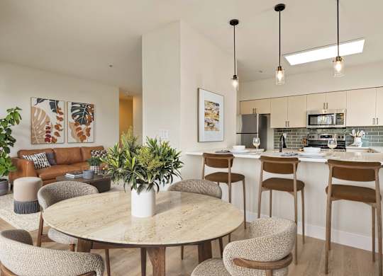 A modern living room with a dining area and kitchen in the background.