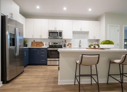 a kitchen with a large island with two stools