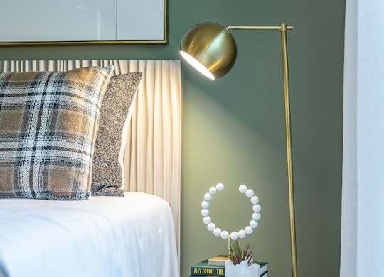 a bedroom with a bed and a lamp and a table