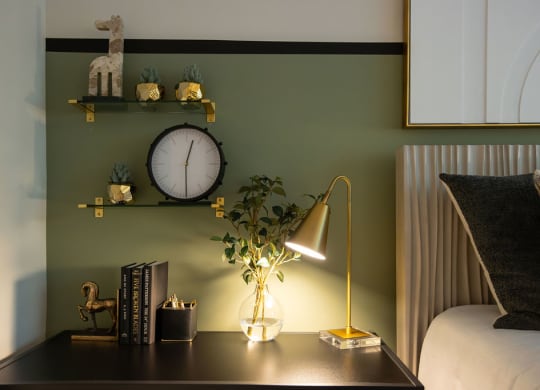 a desk with a lamp and a clock on a wall