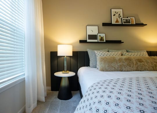a bedroom with a bed and a lamp and a window