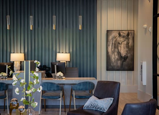 a living room with blue chairs and a table with a horse painting