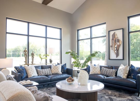 a living room with couches and a coffee table and large windows