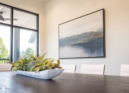 a dining room with a table and a painting on the wall