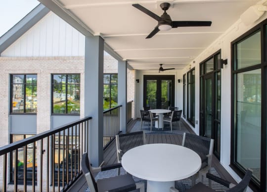 a porch with a table and chairs and a ceiling fan
