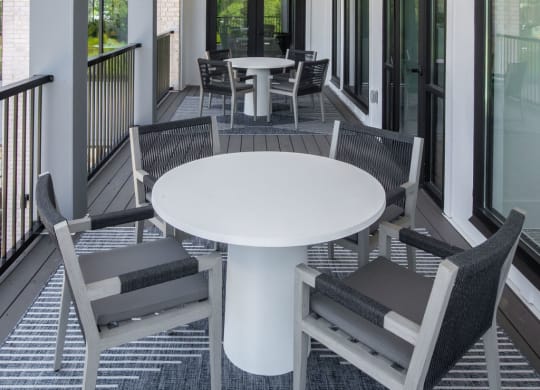 a covered porch with a white table and chairs