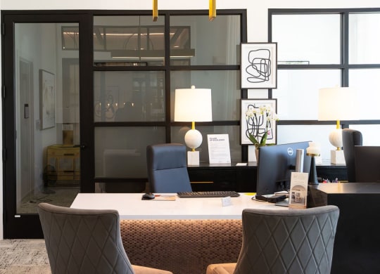 a desk with a computer and chairs in an office