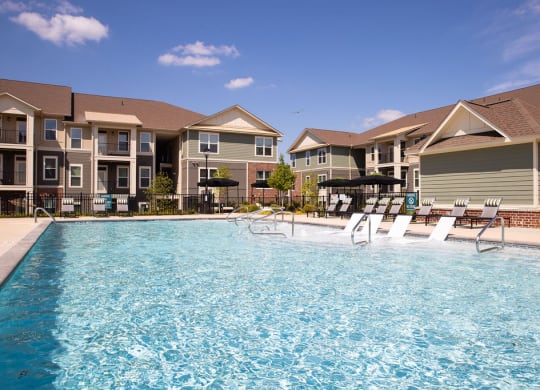 a swimming pool in front of a row of apartment buildings