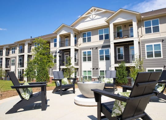 an outdoor area with chairs and tables in front of an apartment building