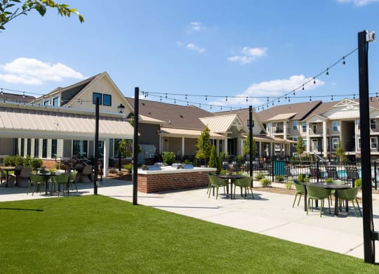 a patio with tables and chairs in front of houses