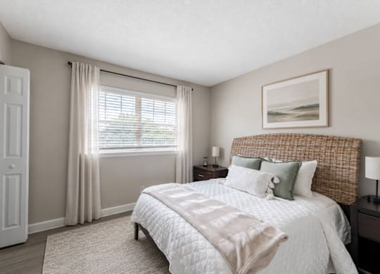A bedroom with a large bed and a painting on the wall.