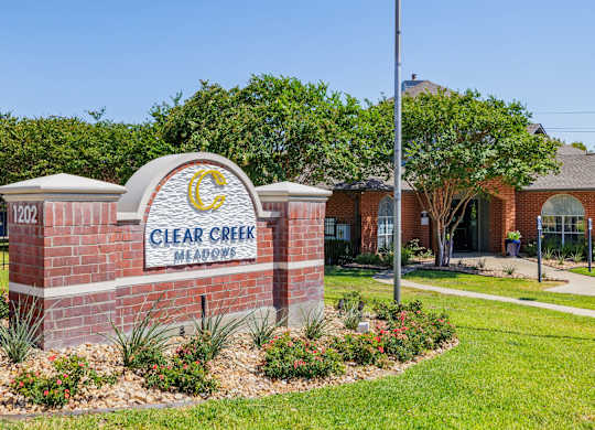 a brick sign with the words clear creek memories in front of a brick building at Clear Creek Meadows Apartments, Copperas Cove, 76522