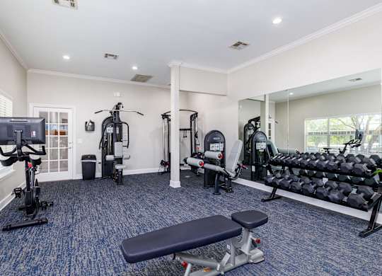 a gym with cardio equipment and exercise machines at Clear Creek Meadows Apartments, Texas