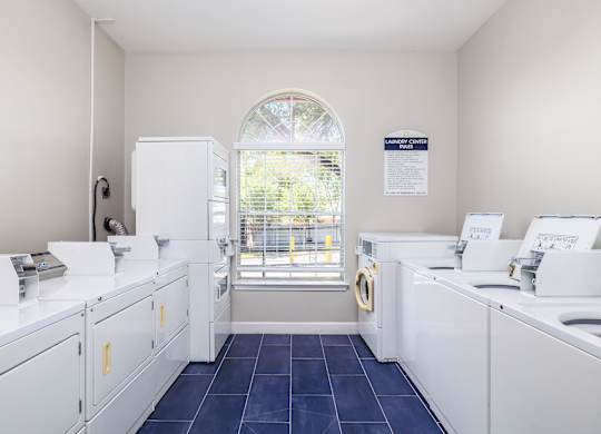 a laundry room with white washers and dryers and a window at Clear Creek Meadows Apartments, Texas, 76522